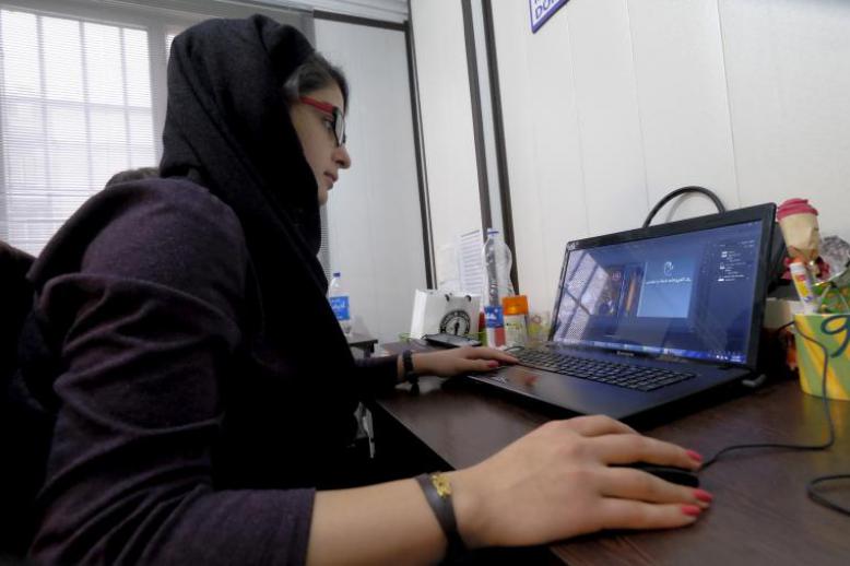 An Iranian woman works on her laptop in Tehran