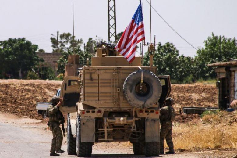 US soldiers climb into a vehicle of the US-led coalition as they prepare to leave the city of Ras al-Ain in Syria's Hasakeh province