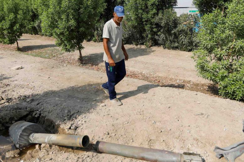 A man glances at a rocket that flew away from an Iraqi militia group's weapons depot after it caught fire, in Baghdad, Iraq