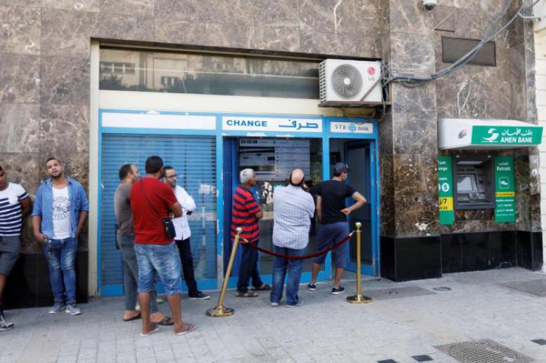 People change money at a currency exchange bank in Tunis