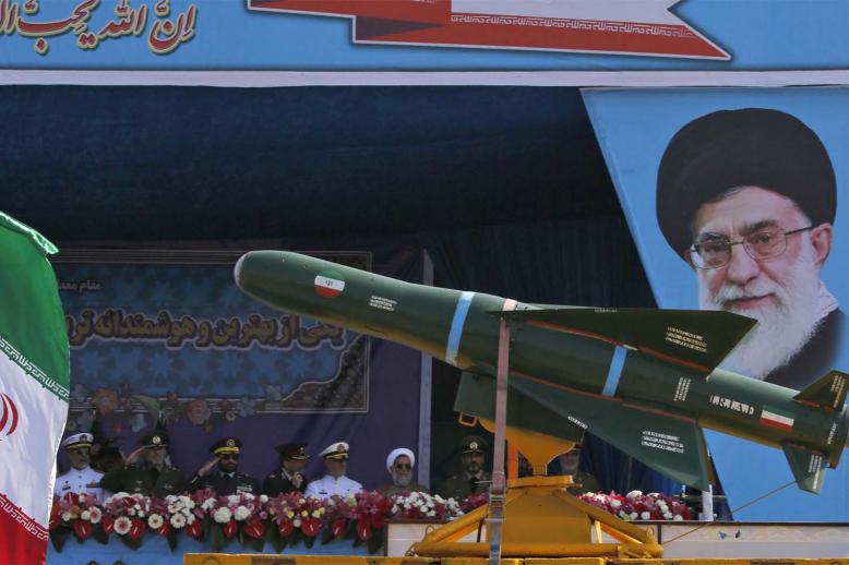 An Iranian military truck carries missiles past a portrait of Iran's Supreme Leader Ayatollah Ali Khamenei during a military parade