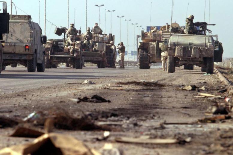 US troops block a highway in outskirts of Baghdad after a roadside bomb attack