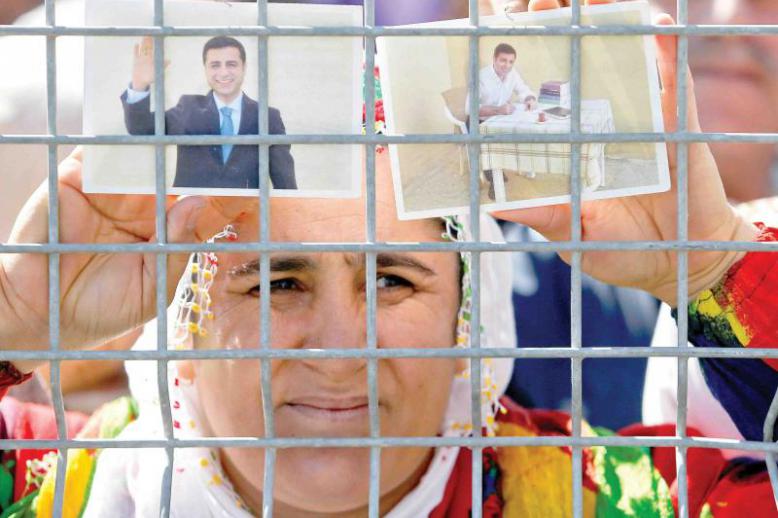 A woman holds pictures of jailed former leader of Turkey’s main pro-Kurdish Peoples’ Democratic Party Selahattin Demirtas