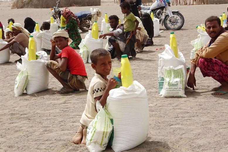 يمنيون فارون من الحرب يتلقون مساعدات غذائية في الحديدة