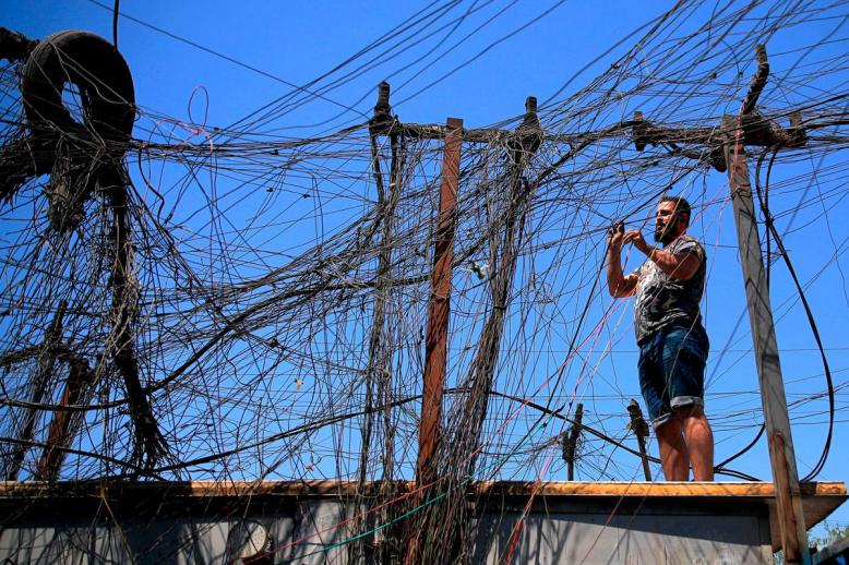 عراقي يصلح رابطا لشبكة كهرباء من مولدات محلية في بغداد