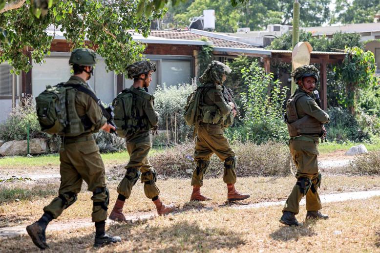 Israeli soldiers patrol in kibbutz Kfar Aza in southern Israel near the Gaza Strip