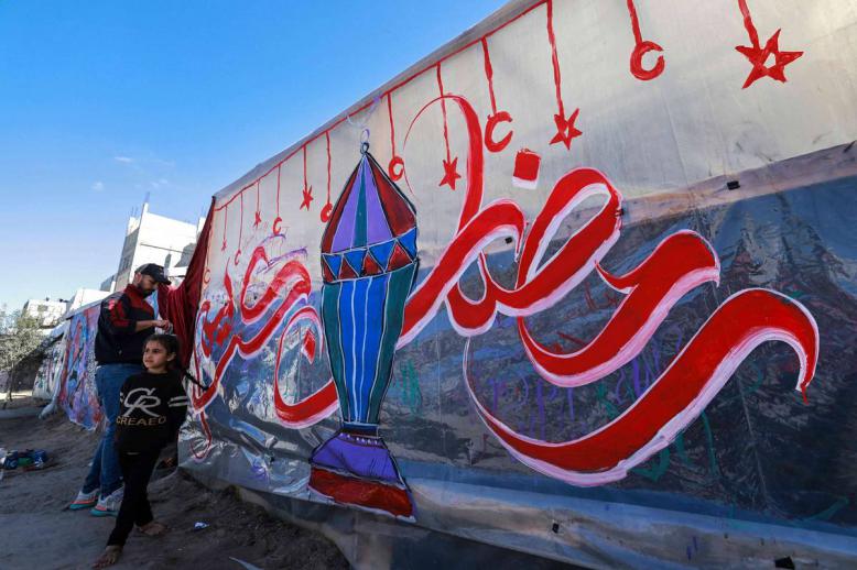 فلسطيني يخط على جدار احتفالا برمضان