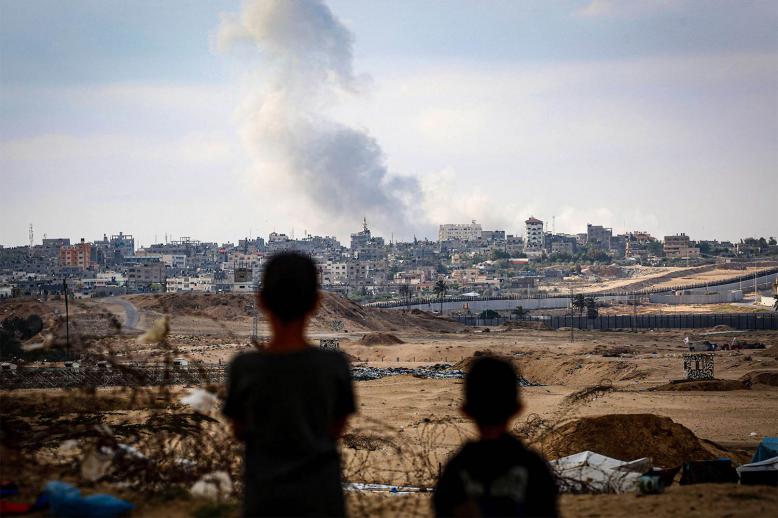 Boys watch smoke billowing during Israeli strikes east of Rafah in the southern Gaza Strip 