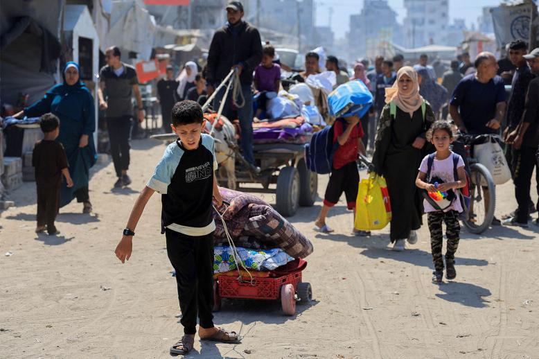 Palestinians fleeing with their belongings after the Israeli army issued evacuation orders, in Khan Younis