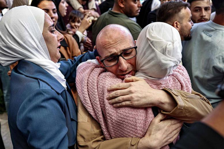 One of the Palestinian prisoners, who was released in a prisoner-hostage swap and ceasefire deal between Israel and Hamas, is embraced by a woman relative upon arrival by bus at Ramallah Cultural Centre in Ramallah