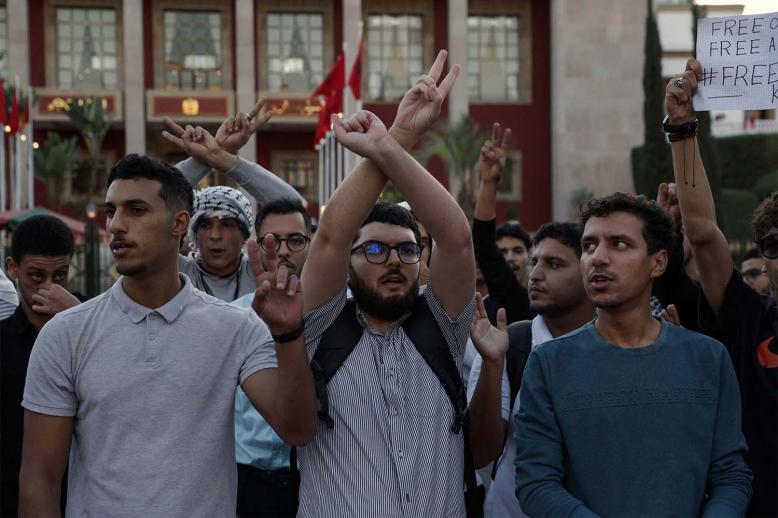Demonstrators gesture during a youth-led protest demanding reforms to public healthcare and education in front the Parliament in Rabat