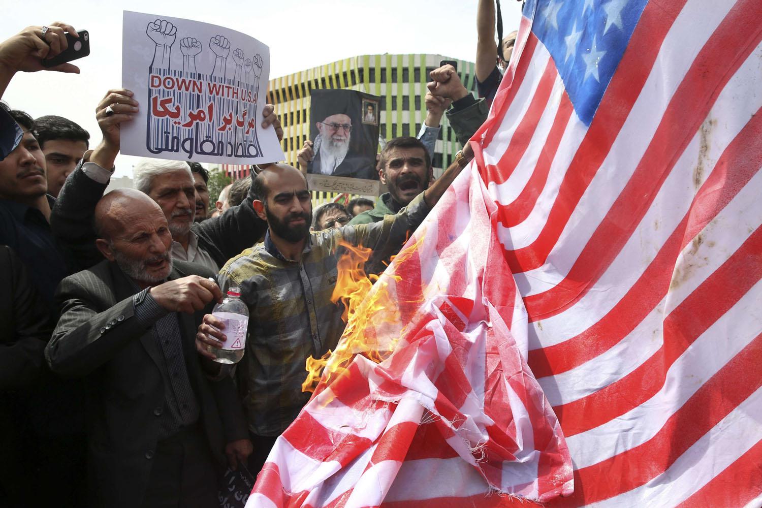 متظاهرون إيرانيون يحرقون علما أميركيا احتجاجا على الغاء الاتفاق النووي