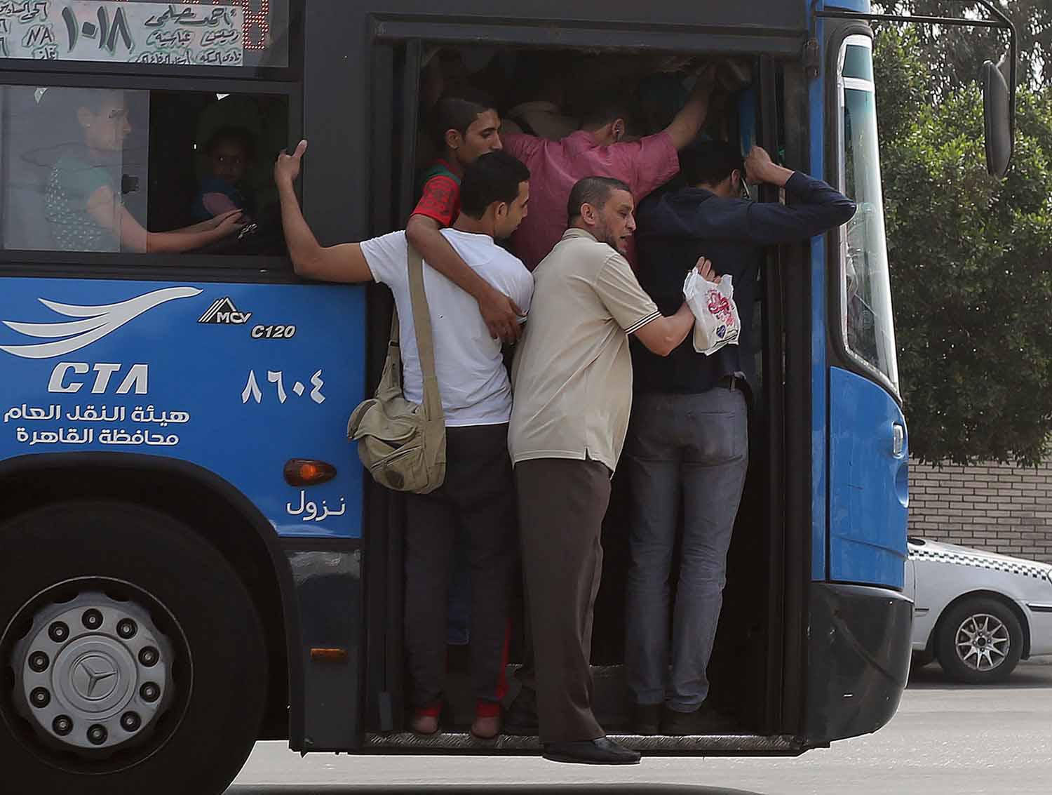 مصريون يتزاحمون اثناء ركوب أوتوبيس للنقل العام