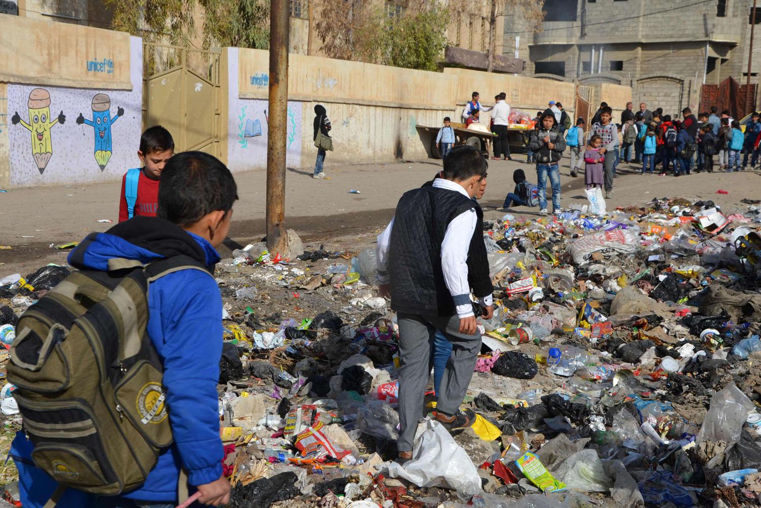  أطفال يجتازون مزبلة للوصول إلى مدارسهم