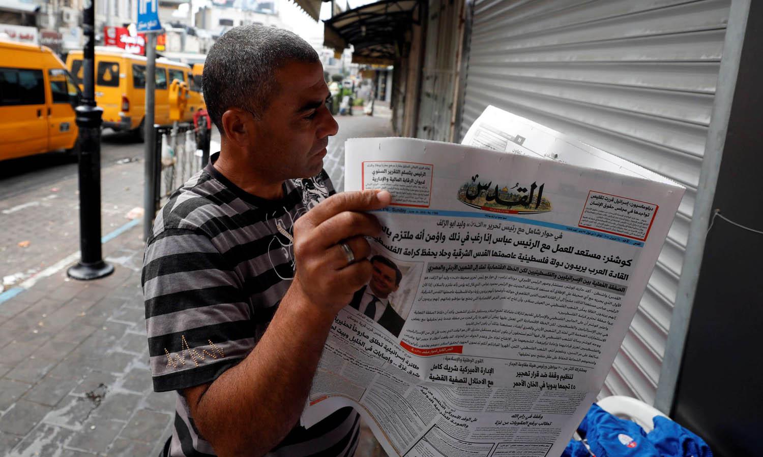 فلسطيني يقرأ صحيفة في رام الله