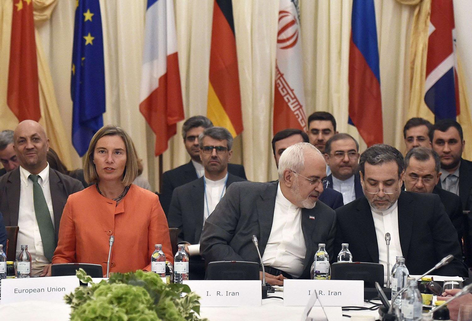 وزير الخارجية الإيراني محمد جواد ظريف يتحدث إلى نائبه عباس عراقجي بحضور مسؤولة الشؤون الخارجية في الاتحاد الأوروبي فردريكا موغيريني