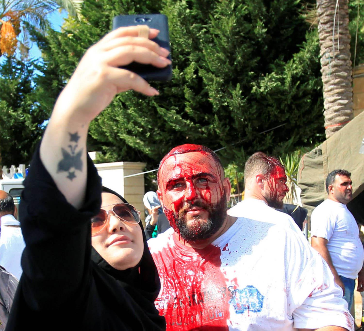 لبنانية تأخذ صورة سيلفي مع شيعي لبناني يشارك بالتطبير في عاشوراء