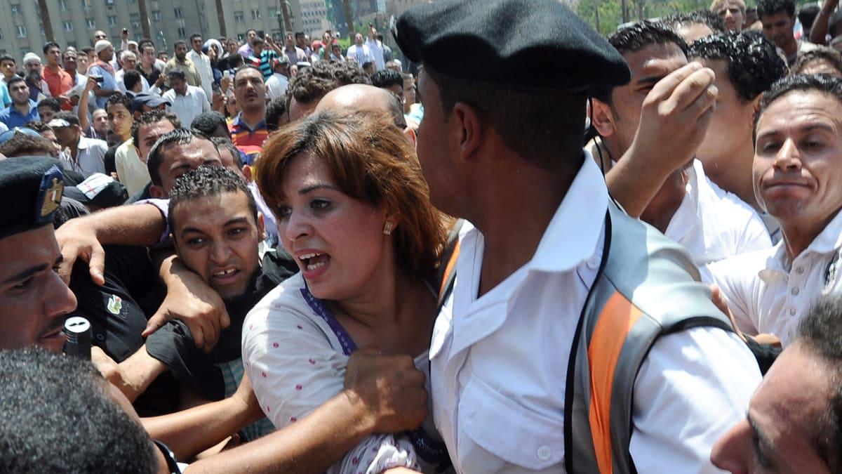 فتاة تحتمي بشرطي مصري وسط حشد غفير من الرجال