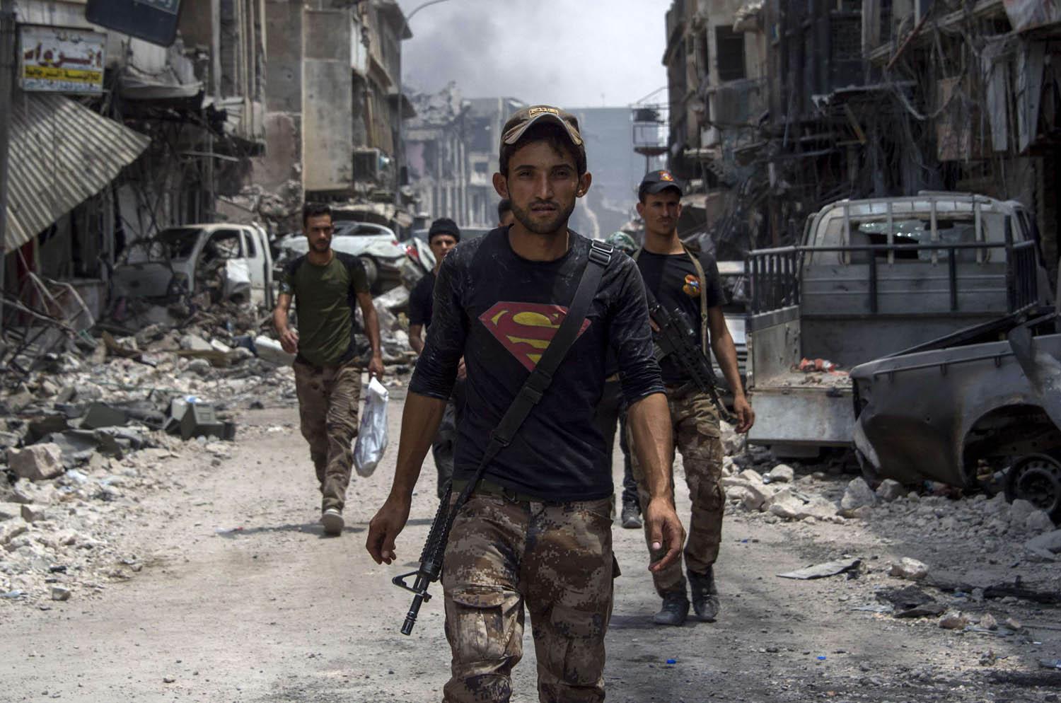 مقاتلون من الحشد الشعبي يتجولون بين خرائب الموصل