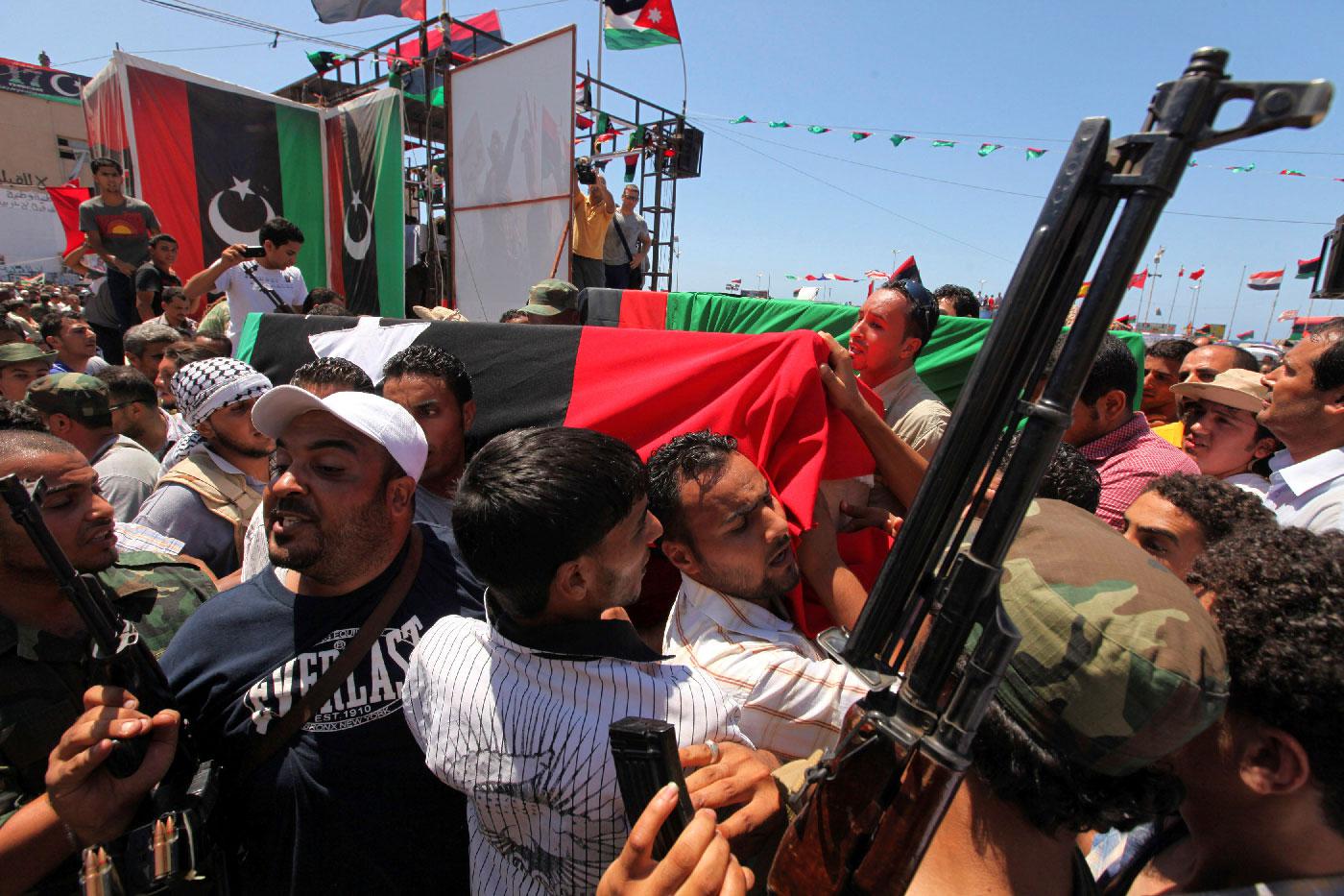 People attend the burial of Libyan rebel military commander Abdel Fattah Younes in Benghazi July 29, 2011.