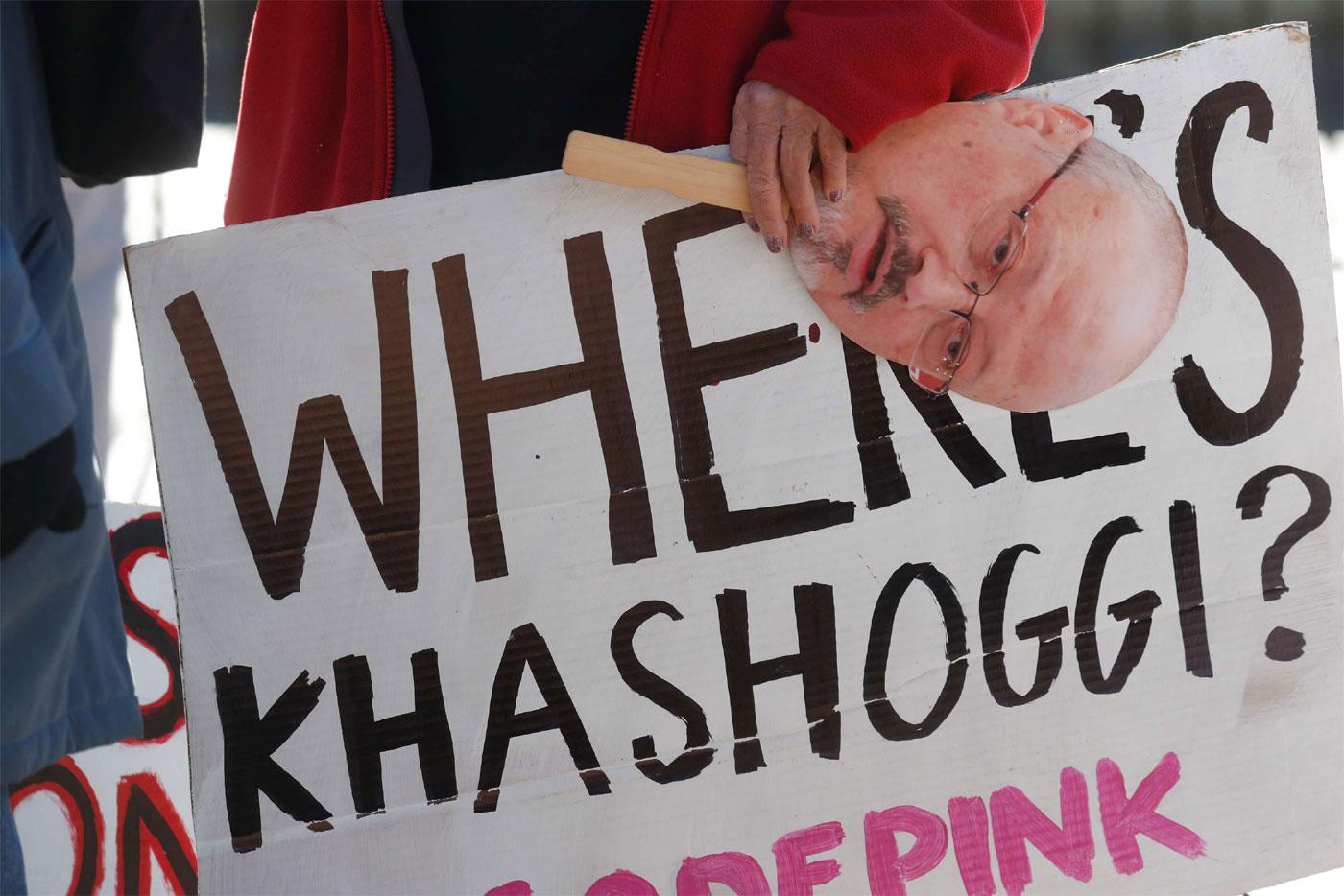 An activist holds a sign and image of missing Saudi journalist Jamal Khashoggi during a demonstration in Washington