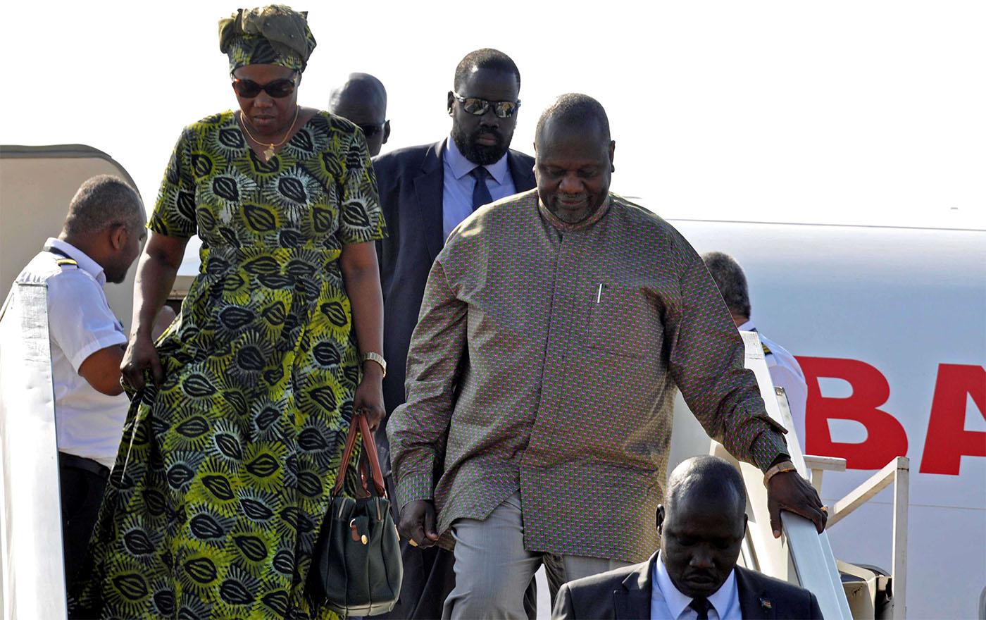 South Sudan rebel leader Riek Machar and his wife Angelina Teny disembark from the plane after arriving at Juba airport in South Sudan