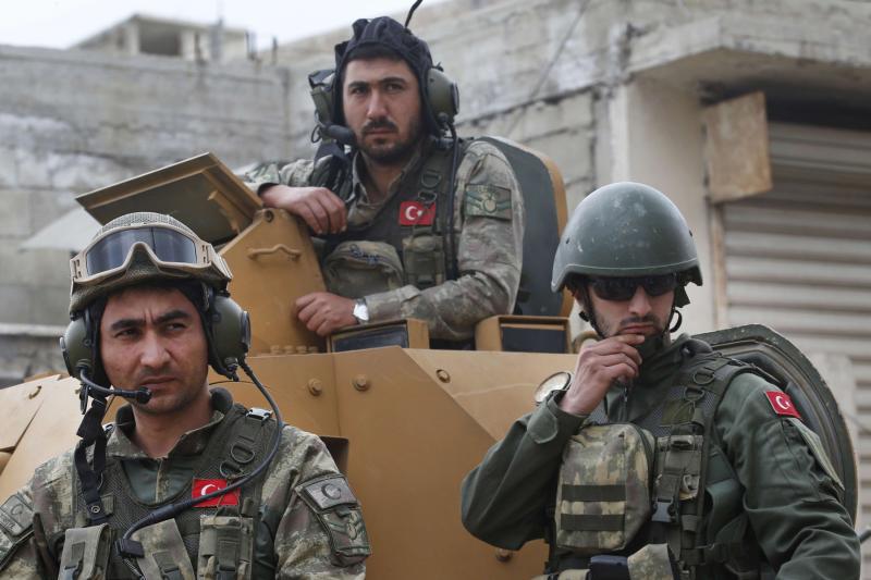 Turkish soldiers atop an armoured personnel carrier secure the streets of the north-western city of Afrin, last March