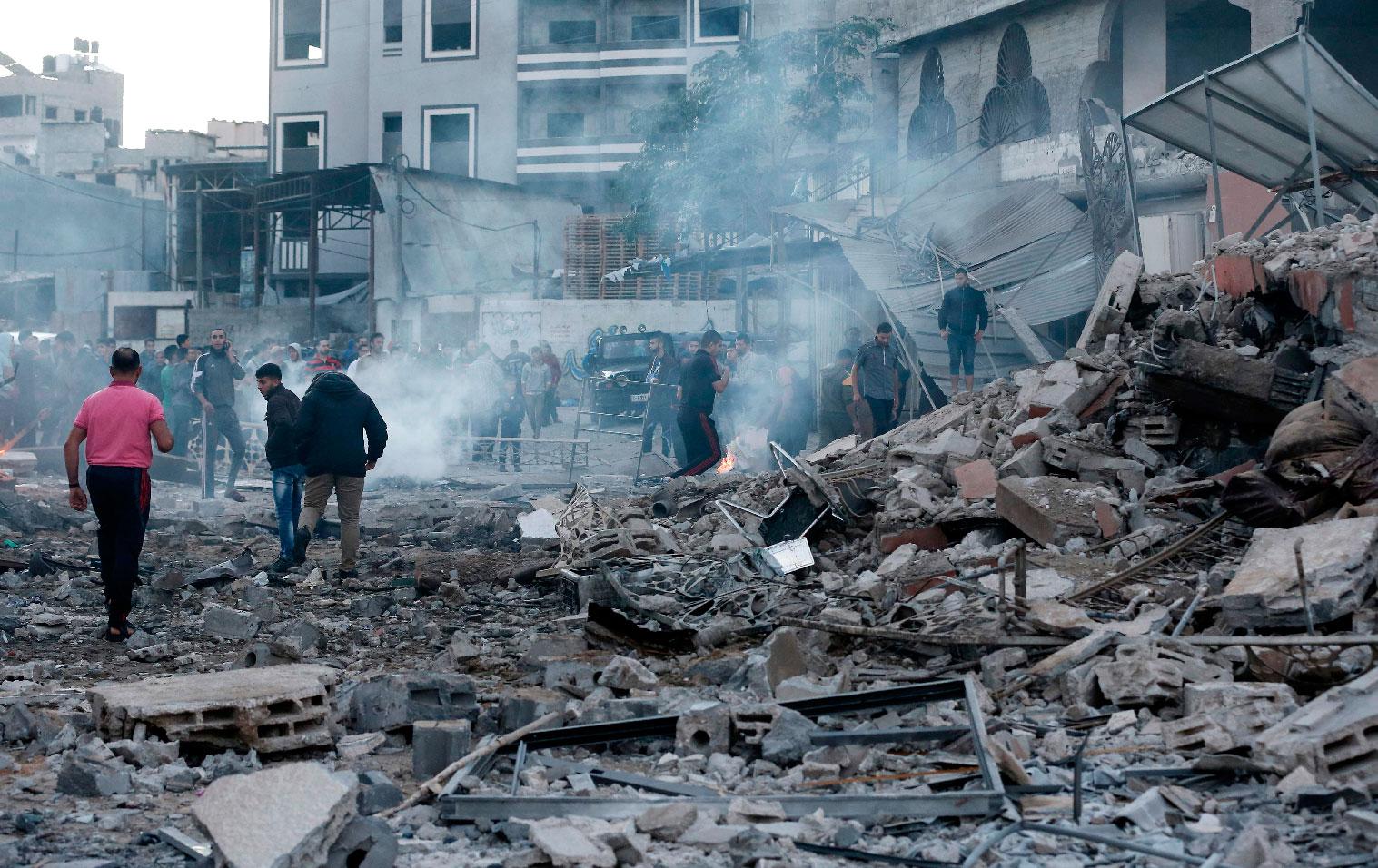 People inspect the rubble of a building following an Israeli air strike on Gaza City on October 27, 2018.