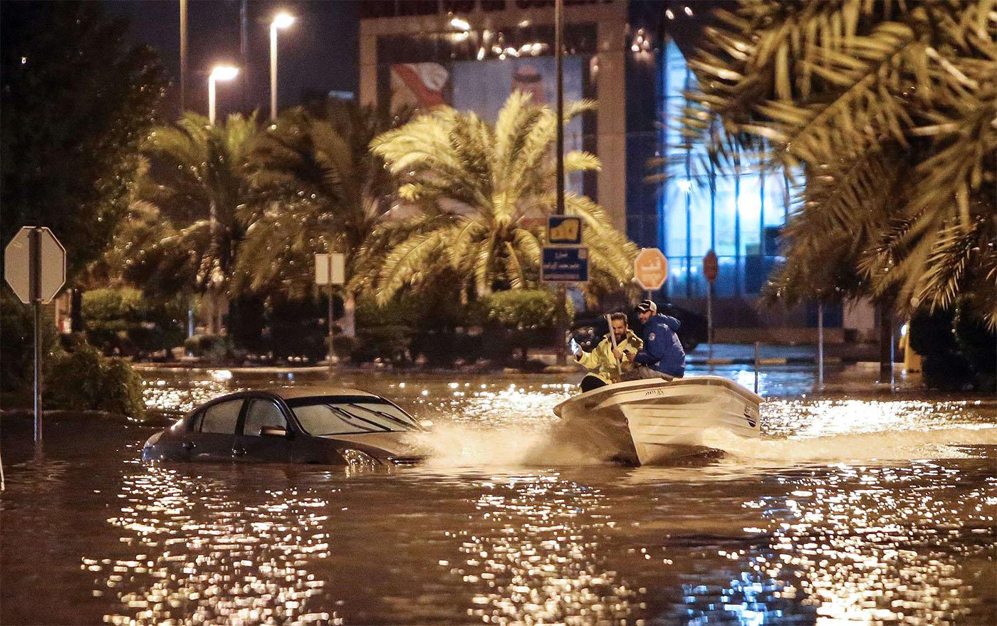 People are using a boat on the flooded main road of the Daeya area of Kuwait city 