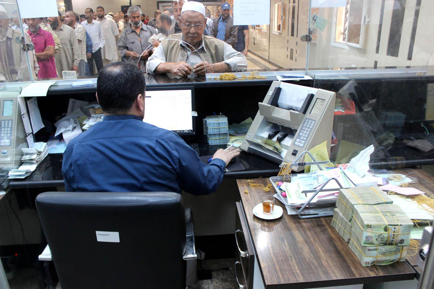 ليبيون يقفون في طابور أمام صراف في مصراتة