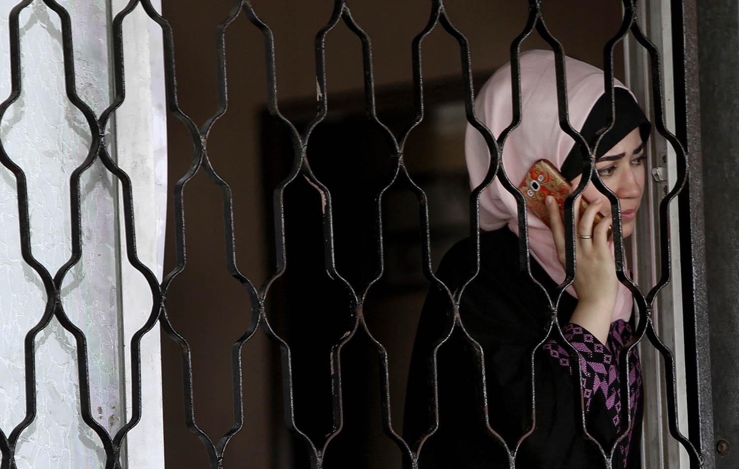 فلسطينية تتحدث في الهاتف عند معبر رفح مع مصر