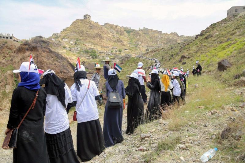 Yemenis receive food aid from the UAE Red Crescent in the country's third-city of Taiz, on October 16