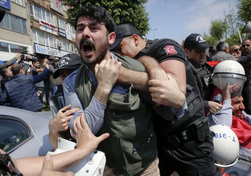 A demonstrator screams as police officers grab him during a protest in Istanbul