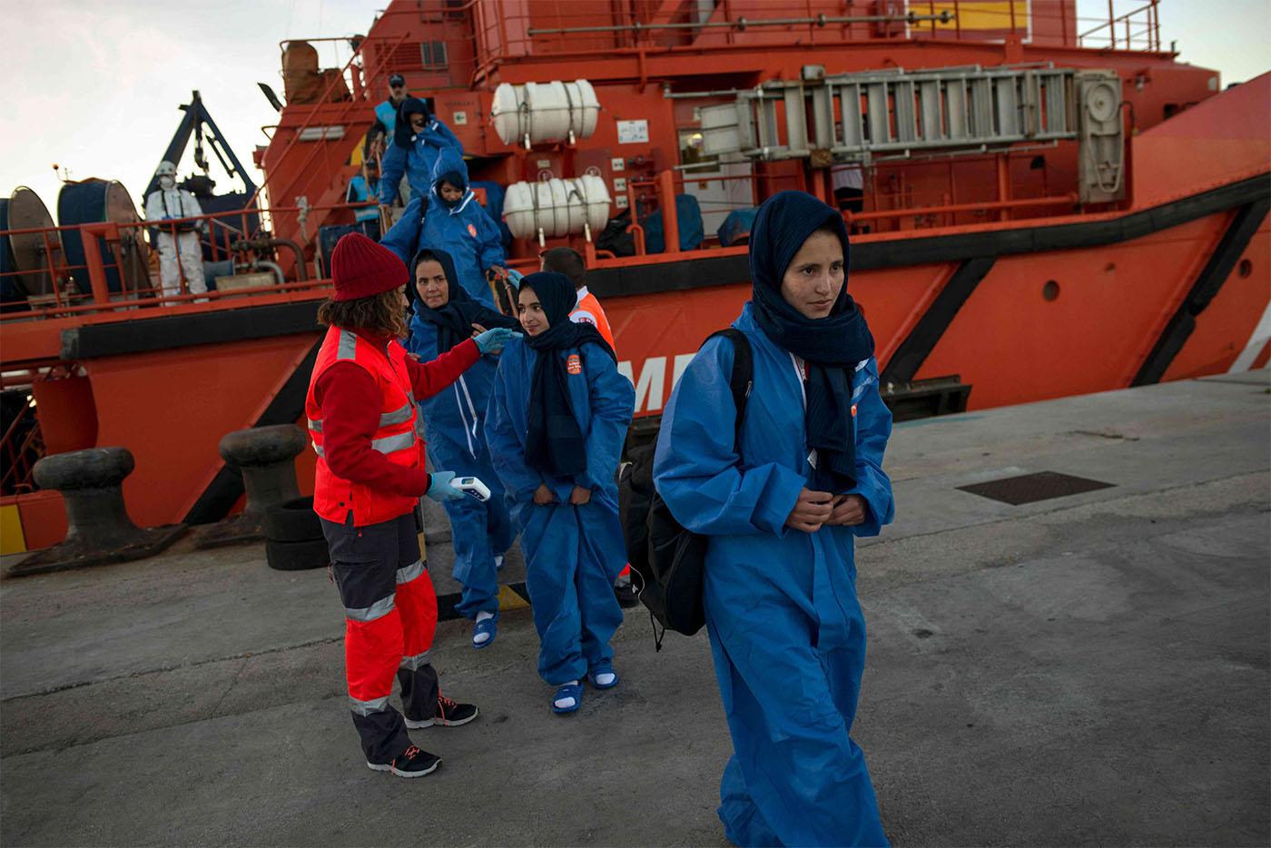 Migrants are transferred upon their arrival aboard a coast guard boat at Algeciras' harbour 