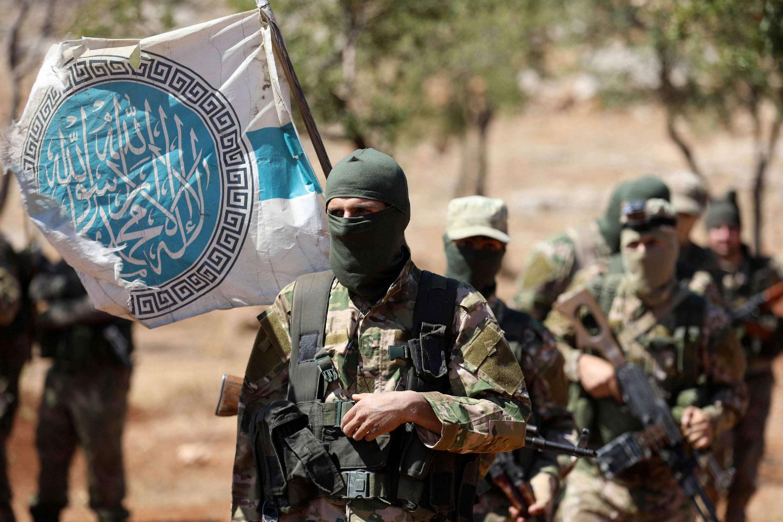 Syrian fighters attend a mock battle in anticipation of an attack by the regime on Idlib province and the surrounding countryside, during a graduation of new Hayat Tahrir al-Sham (HTS) members at a camp in the countryside of the northern Idlib province on August 14, 2018.
