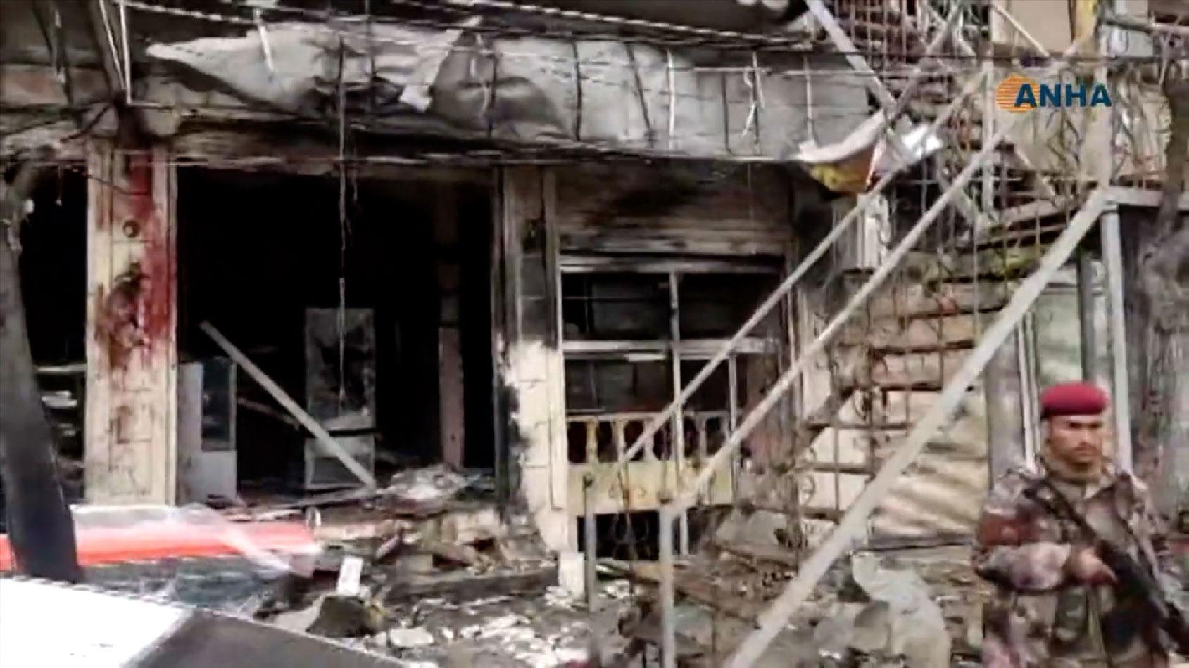 An image grab taken from a video published by Hawar News Agency (ANHA) on January 16, 2019, shows an unidentified member of security forces at the scene of a suicide attack in the northern Syrian town of Manbij.