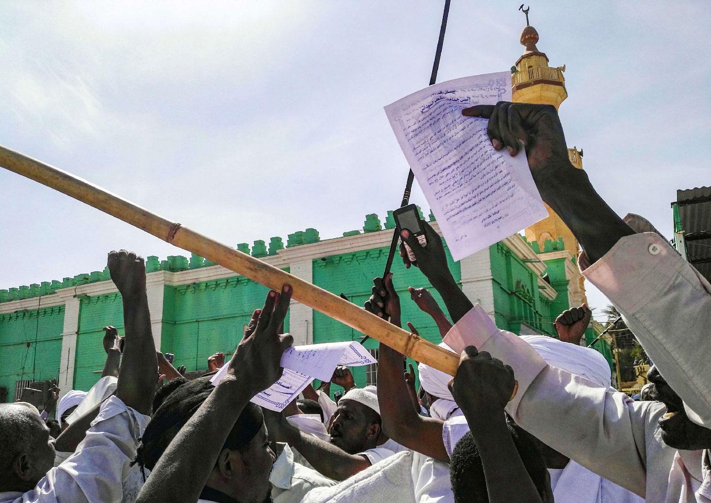 Sudanese protesters chant slogans and raise signs against President Omar al-Bashir during a demonstration in the capital Khartoum's twin city of Omdurman on January 25, 2019.