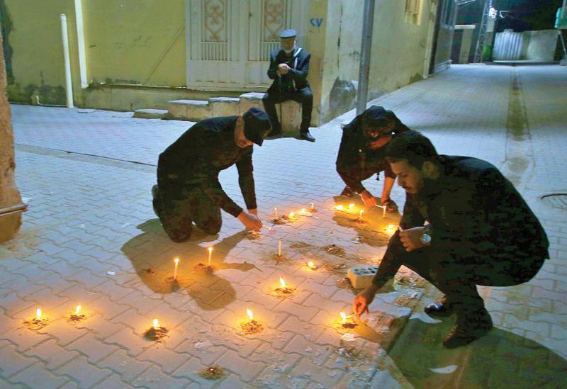 Friends and relatives of Alaa Mashdhub light candles at his assassination site in Karbala, February 5