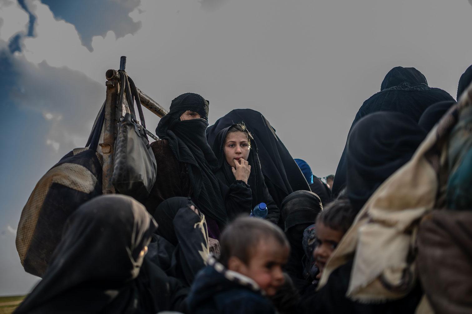 People who fled the Islamic State (IS) group's last holdout of Baghouz, in Syria's northern Deir Ezzor province, sit in a truck, on February 22, 2019.