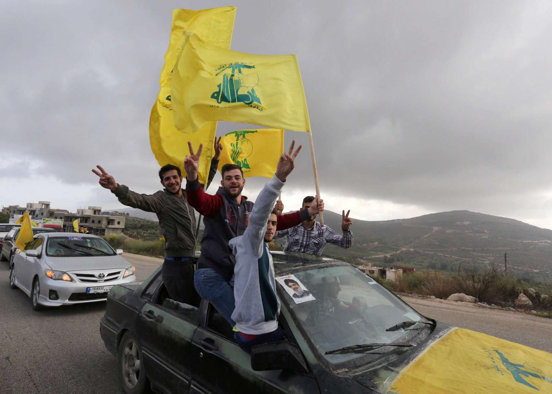 Supporters of Lebanon's Hezbollah leader Sayyed Hassan Nasrallah gesture as they hold Hezbollah flags in Marjayoun, Lebanon May 7, 2018.