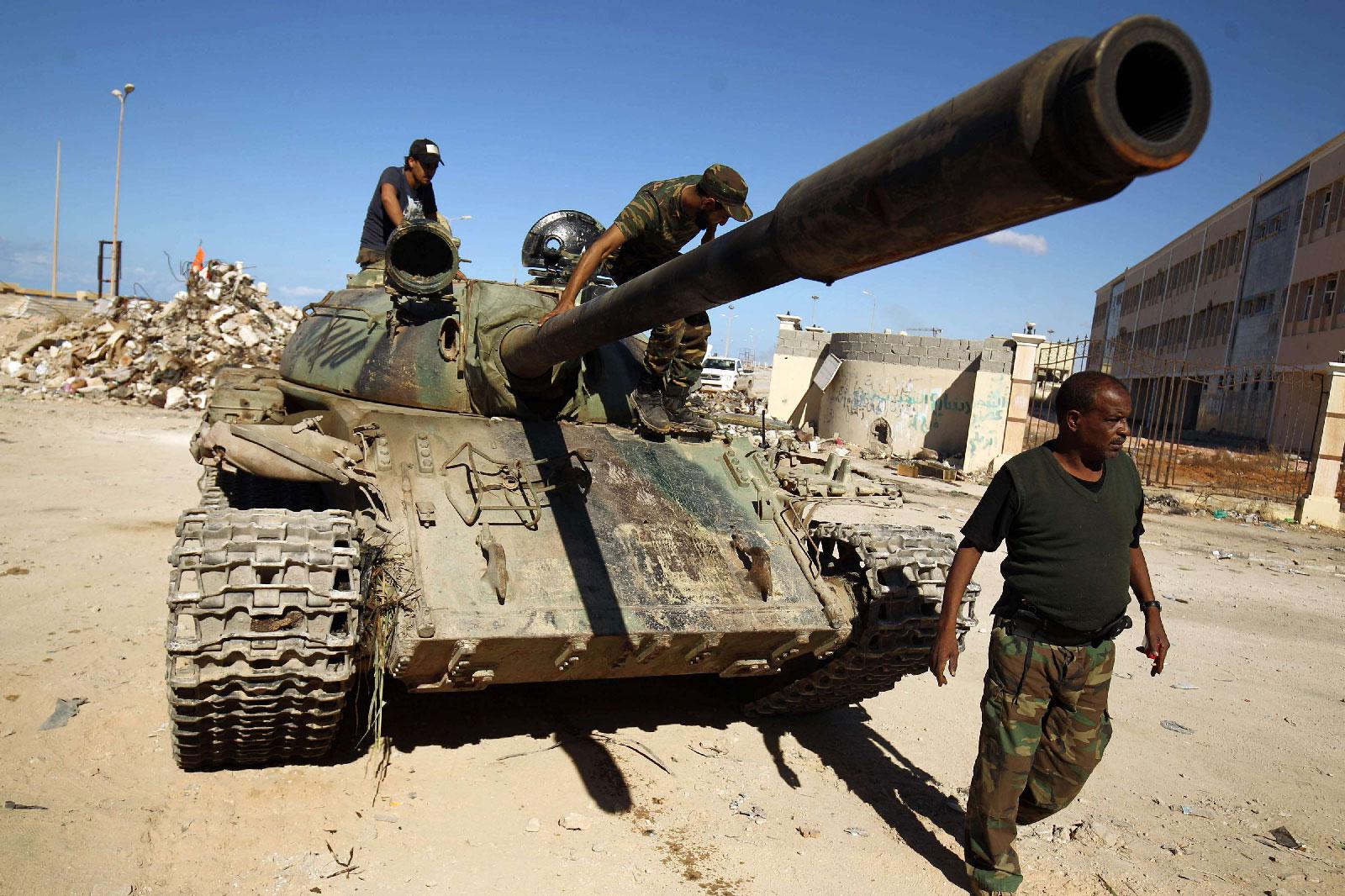 Members of the Libyan National Army ride on a tank.