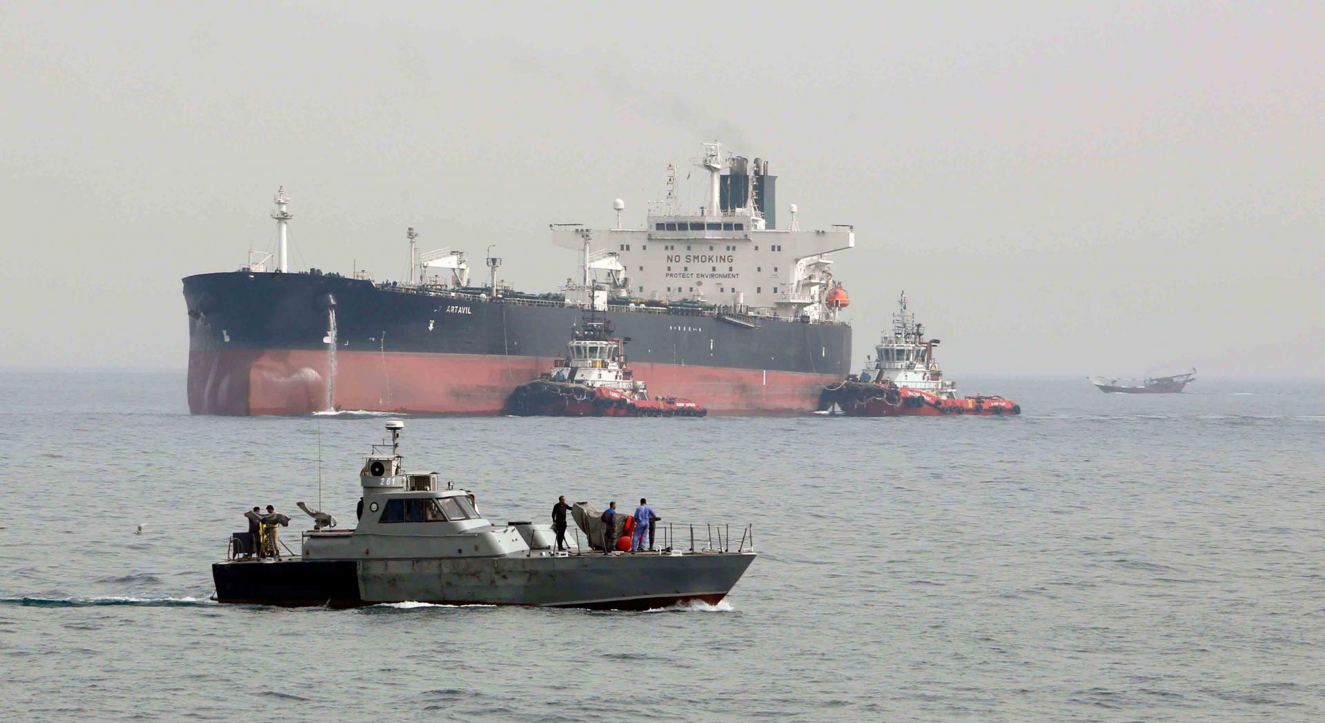 An Iranian military speedboat patrols the waters as a tanker prepares to dock at the oil facility in the Khark Island, Iran