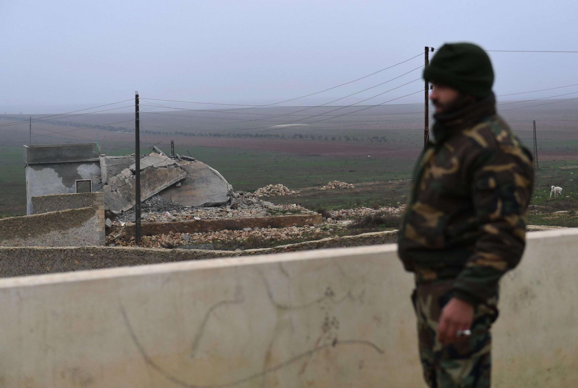 A member of the Syrian regime forces stands on the roof of a building in the southern countryside of the northern Kurdish-controlled city of Manbij on December 30, 2018.