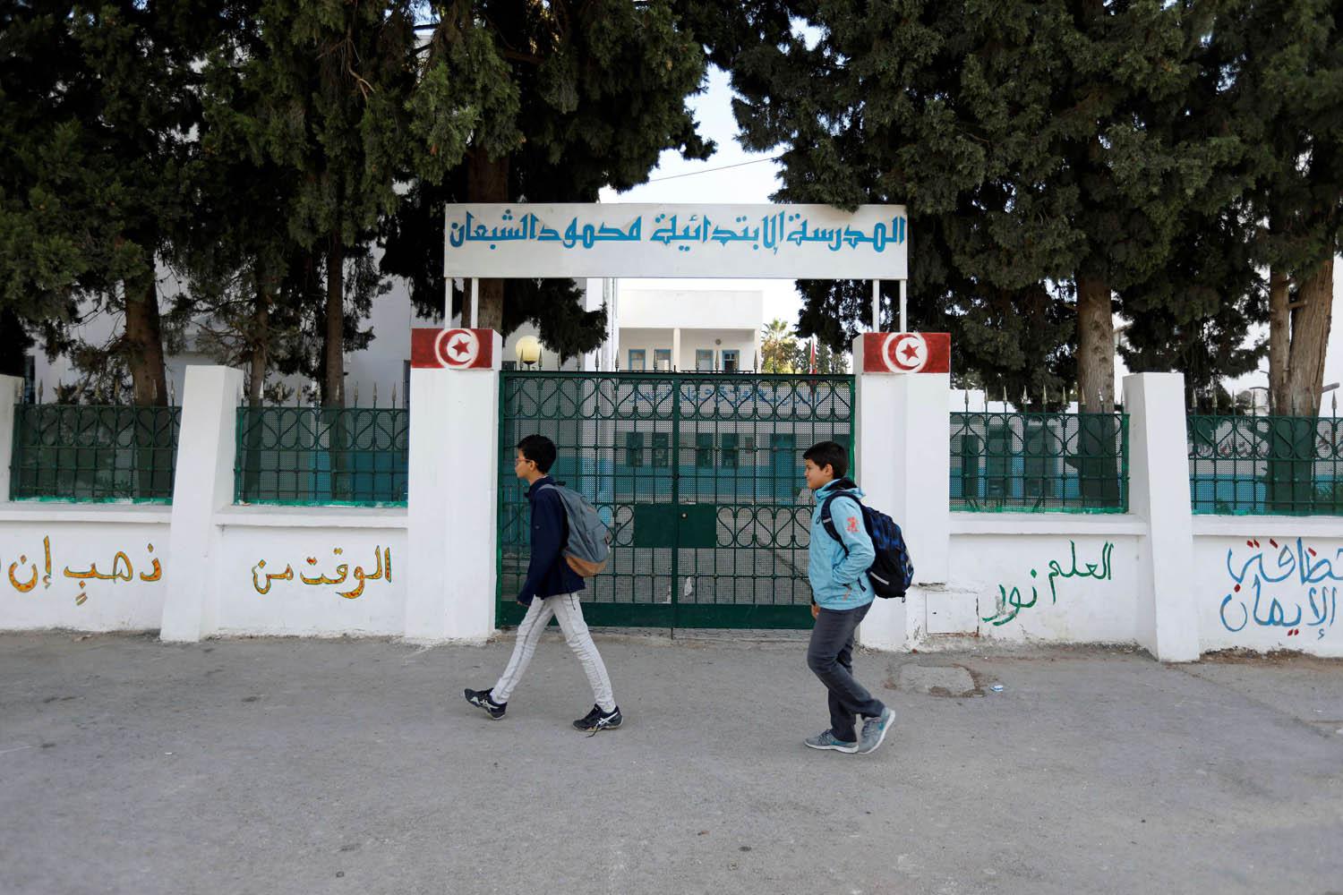 أطفال تونسيون يمرون من أمام مدرسة مغلقة بسبب الاضراب