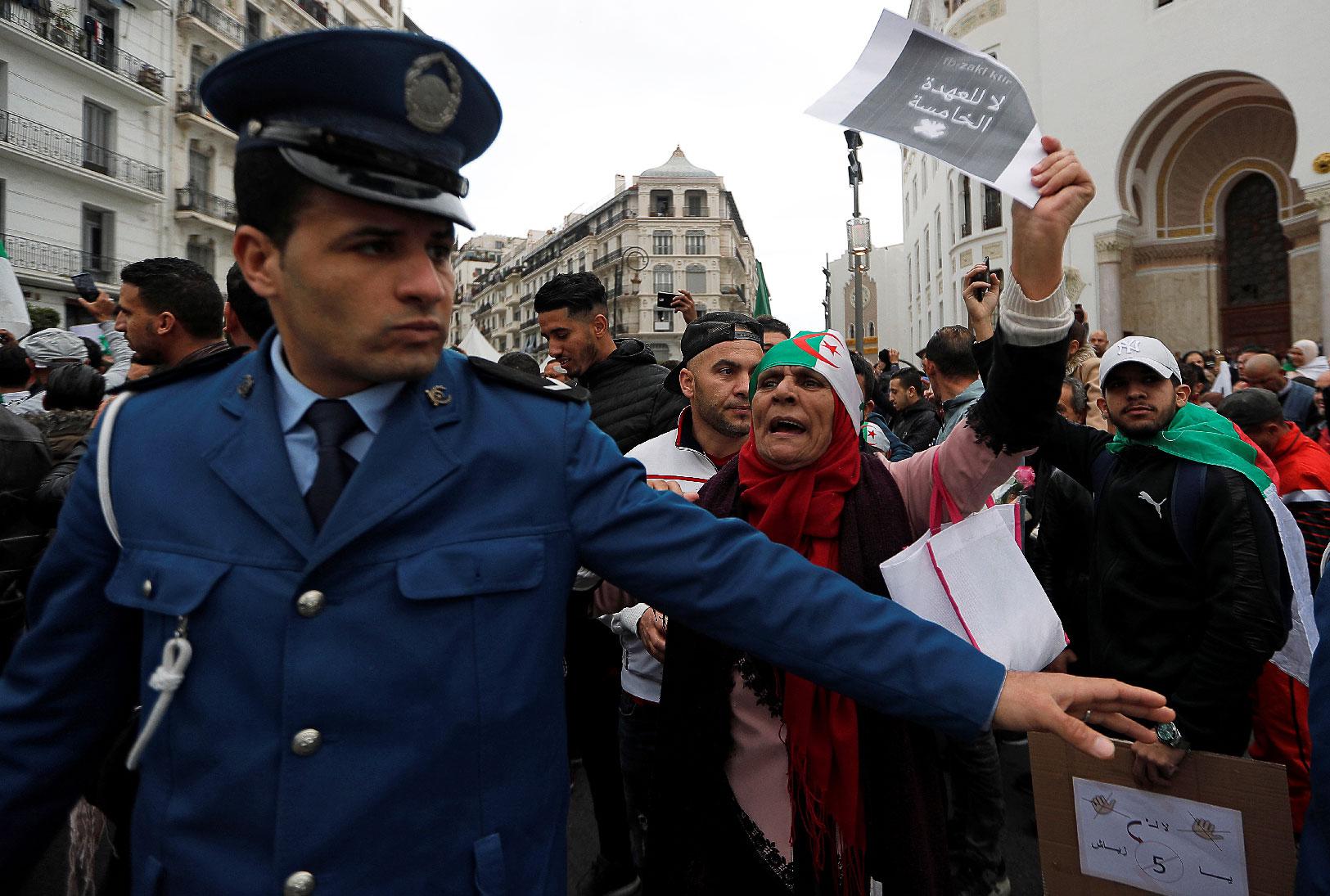 A police officer stands guard as people protest against Algeria's President Abdelaziz Bouteflika, in Algiers, Algeria March 8, 2019.