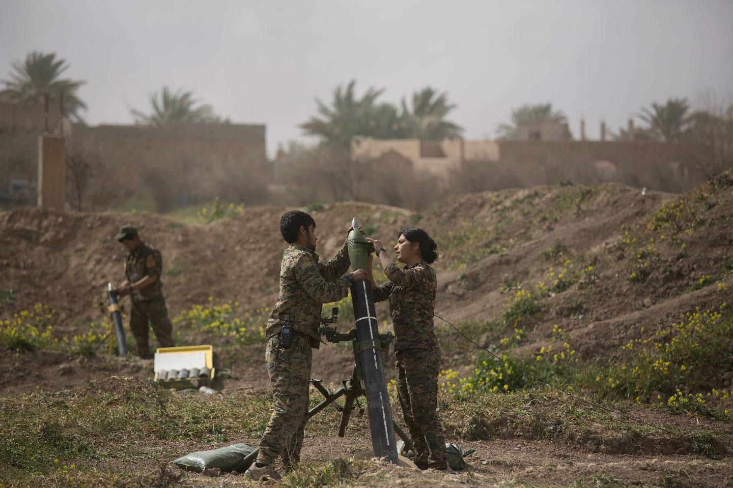 U.S.-backed Syrian Democratic Forces (SDF) soldiers prepare to fire mortars at Islamic State militant positions in Baghouz, Syria, Wednesday, March 13, 2019.