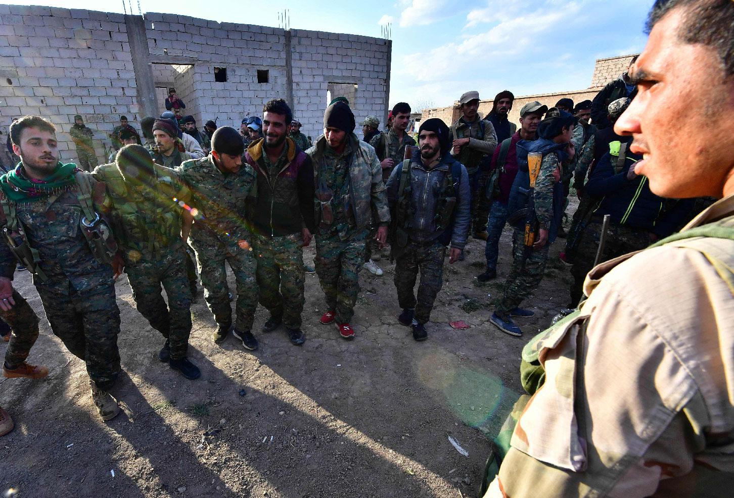 Fighters from the Syrian Democratic Forces (SDF) celebrate as they come back from the frontline in the Islamic State group's last remaining position in the village of Baghouz in the countryside of the eastern Syrian province of Deir Ezzor on March 19, 2019.
