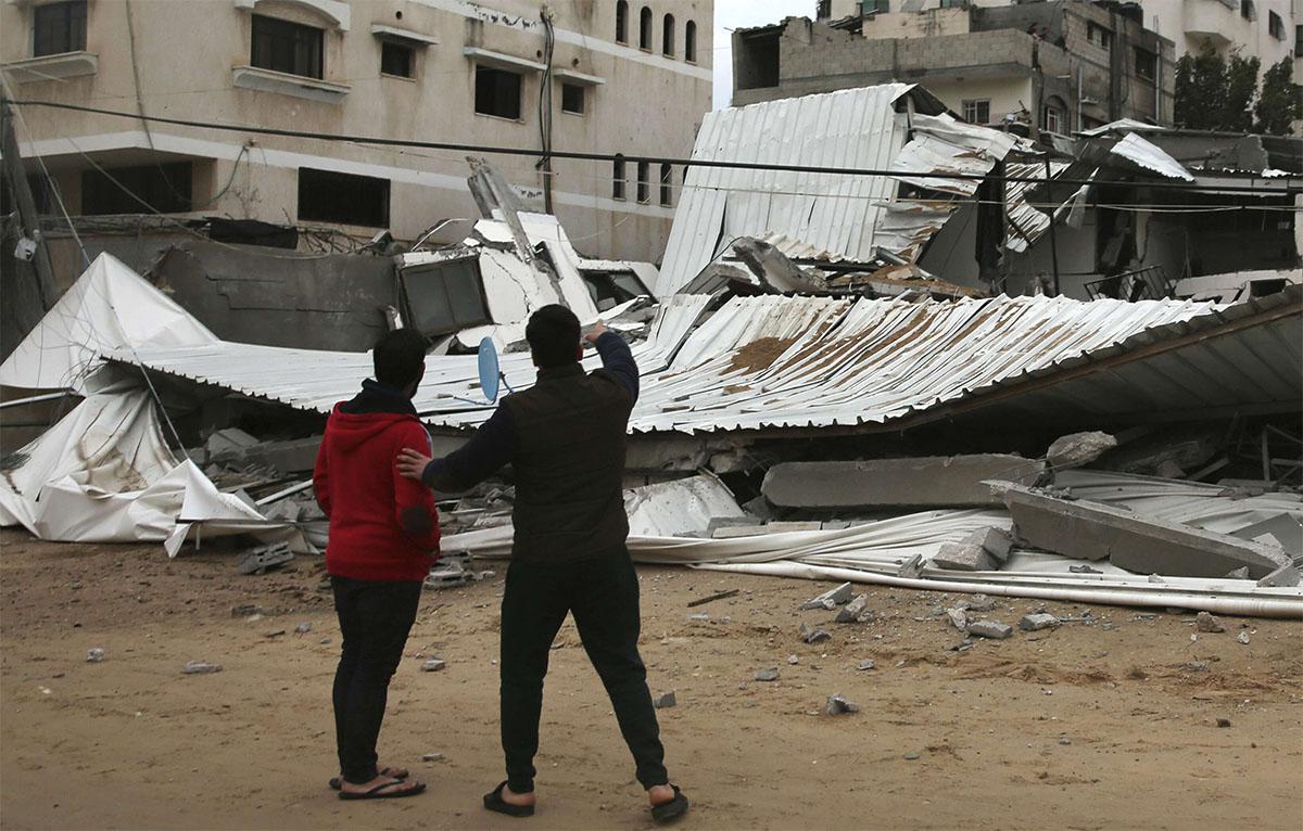 Palestinians inspect the damage of destroyed building belongs to Hamas ministry of prisoners 