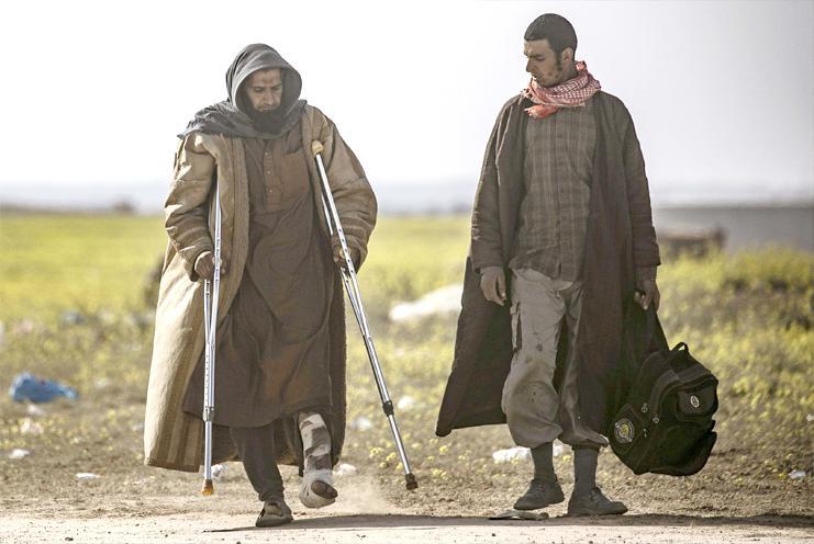 Men suspected of being ISIS fighters walk towards a screening point for new arrivals run by US-backed Syrian Democratic Forces outside Baghouz in the eastern Syrian Deir ez-Zor province, March 5
