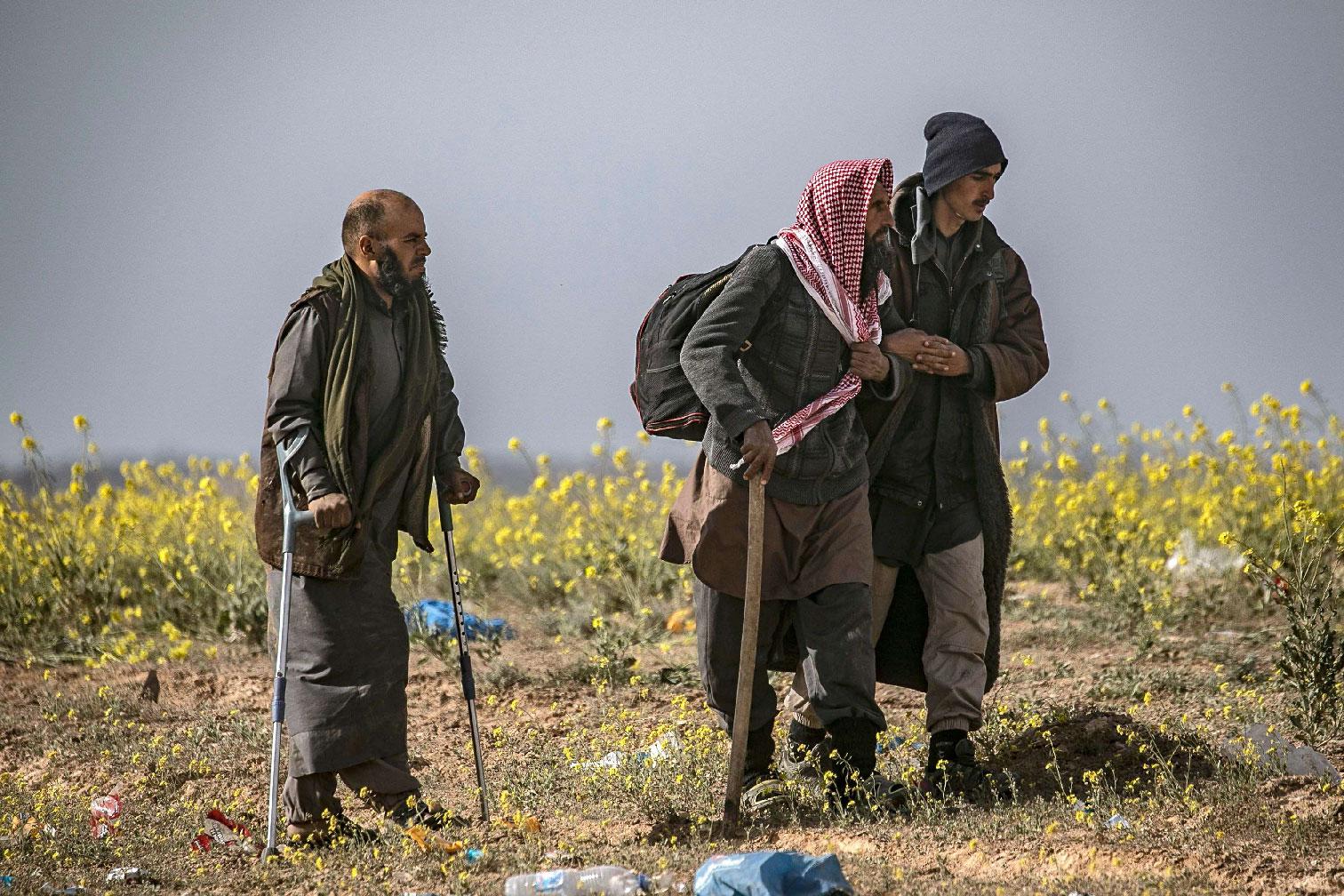 Civilians who streamed out of the Islamic State group's last Syrian stronghold walk towards a screening point for new arrivals run by US-backed Syrian Democratic Forces outside Baghouz in the eastern Syrian Deir Ezzor province on March 5, 2019.